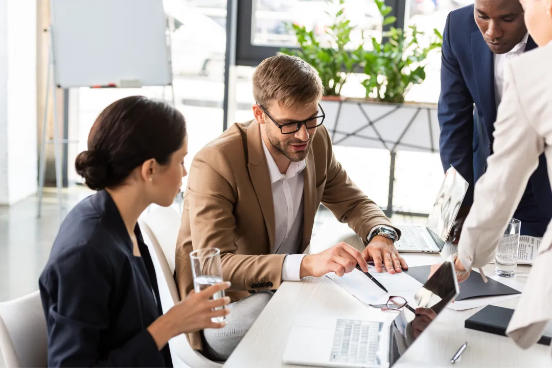 Partial view of multiethnic businesspeople at table during conference in office — Photo